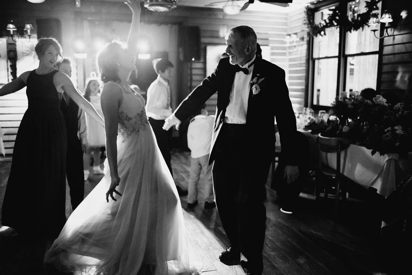 Father of the bride dance with DJ lights backlighting the brides dress