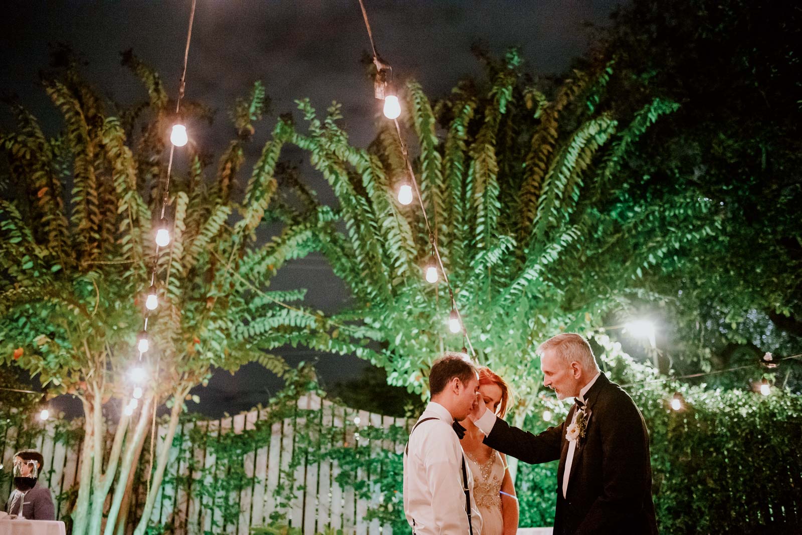 Father of the bride blesses the couple in a quiet moment during a December wedding reception at Ouisie's Table