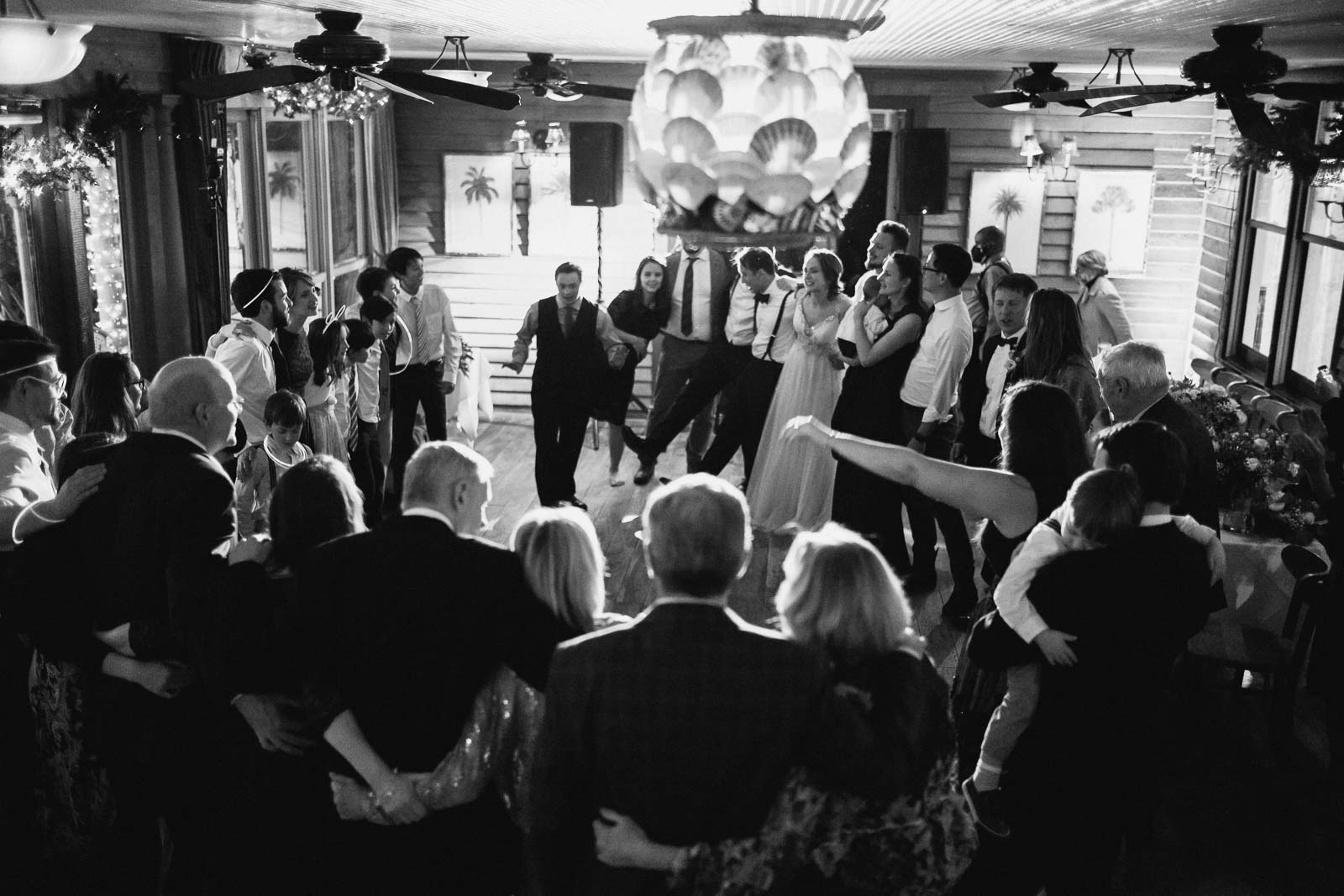 Family make a circle toward the end of a wedding reception at Ouisie's Table in a early winter wedding