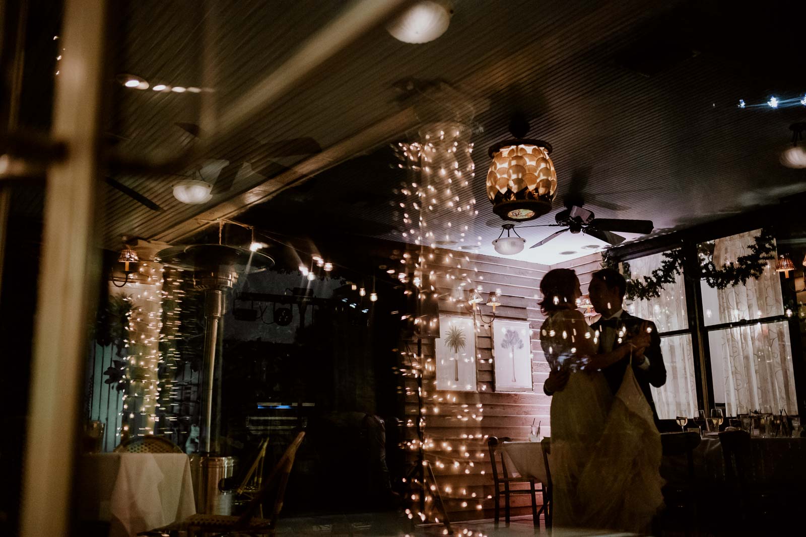 Last dance for wedded couple at Ouisie's Table in Uptown Houston show couple silhouetted through glass