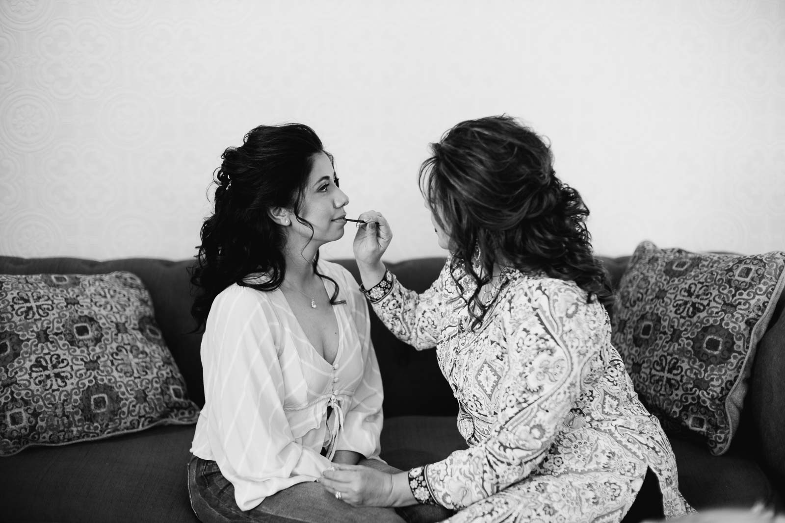 Another the bride applies lipstick to her daughters lips