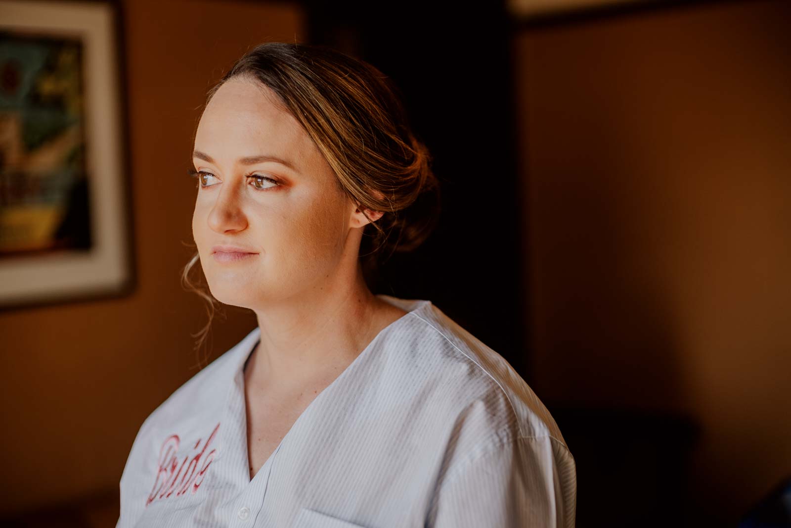 A bride looks out of her hotel window at Hotel Emma on day of her wedding