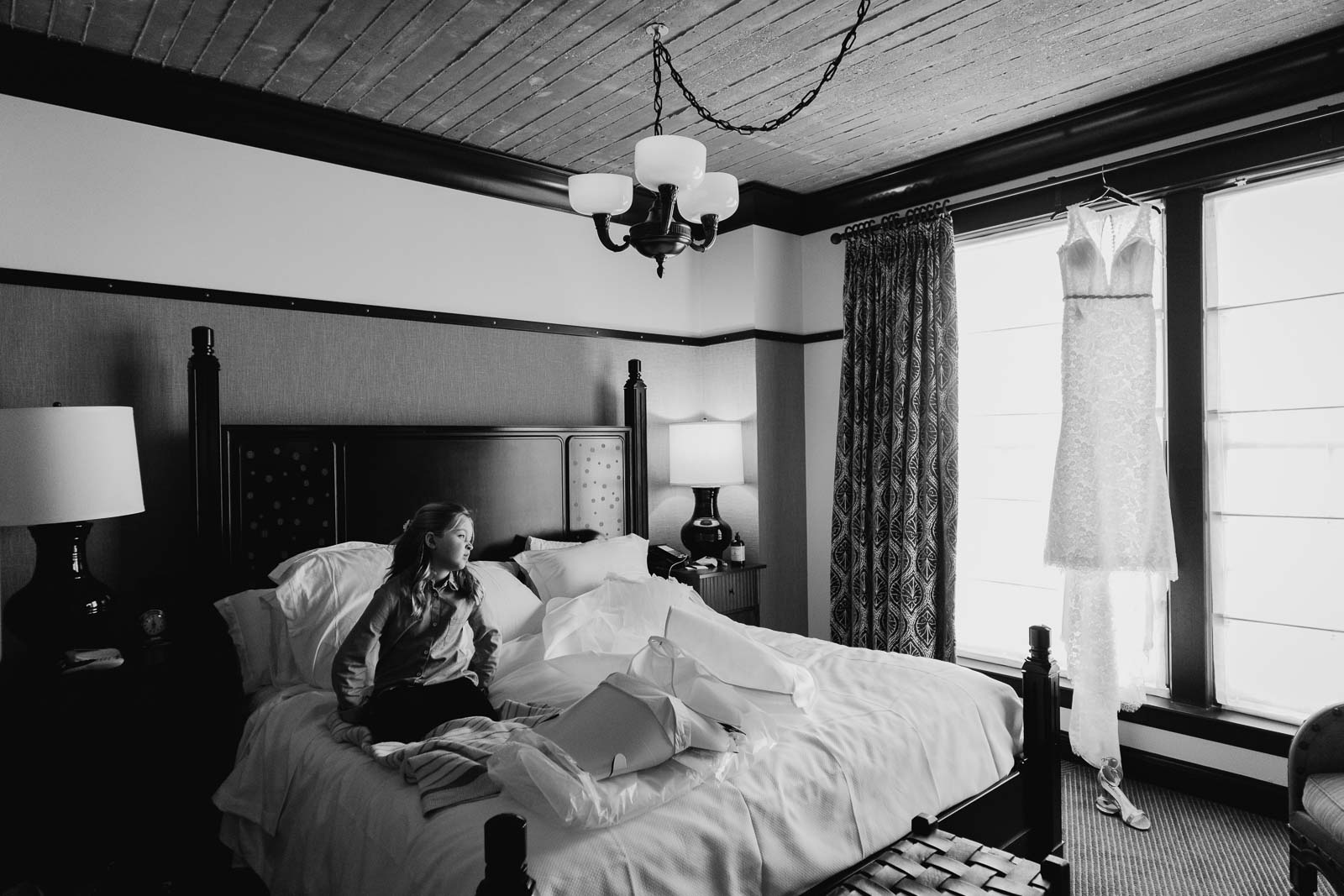 A flower girl views television at the brides dress hangs in a window at Hotel Emma, San Antonio Texas