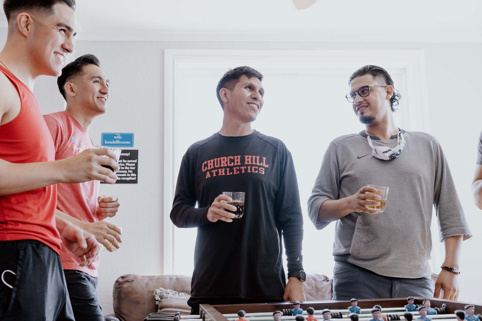 The groomsmen all share a laugh as the groom center of the image and the groomsmen looks at the group