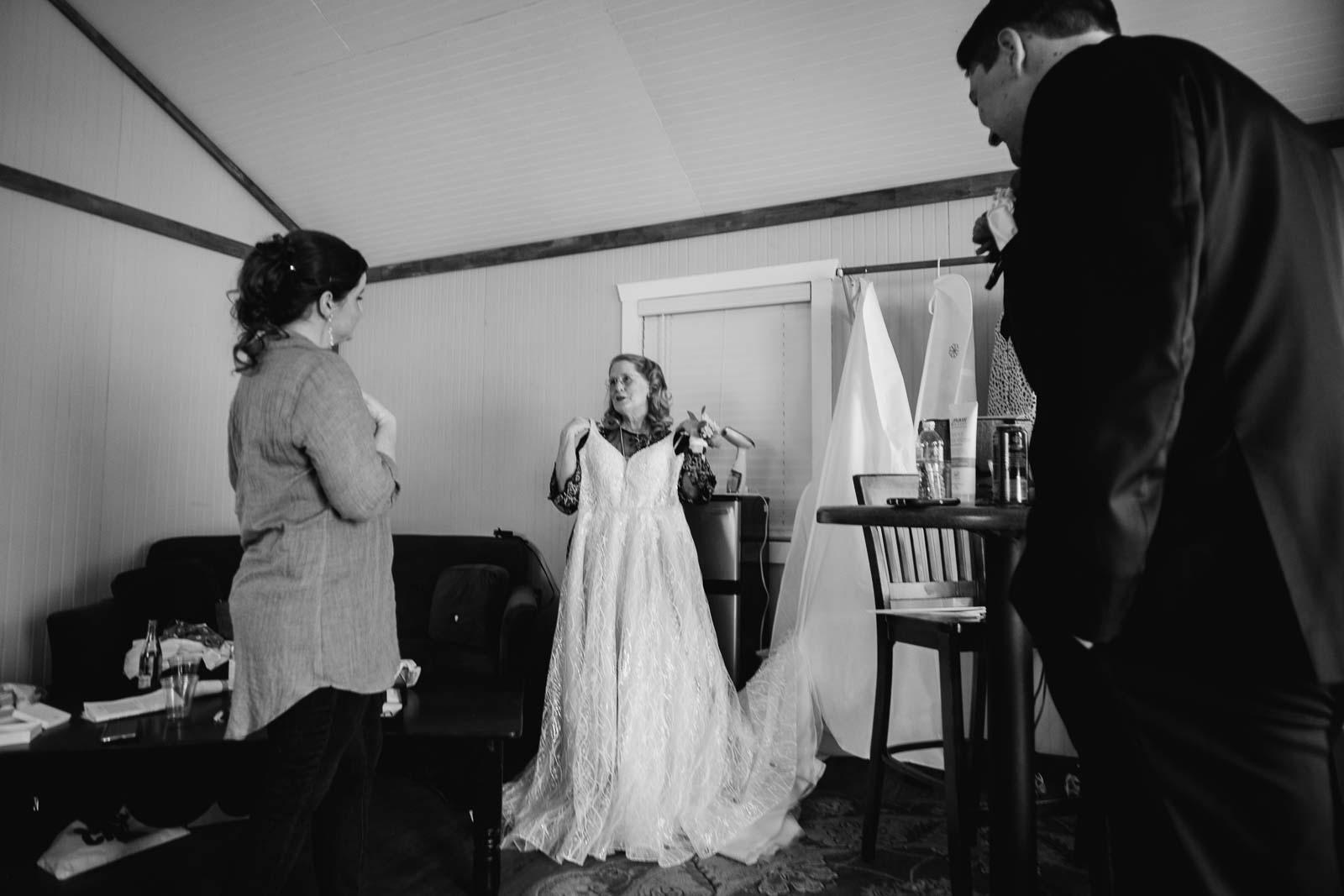 The mother of the bride jokingly hangs the dress up for her to wear
