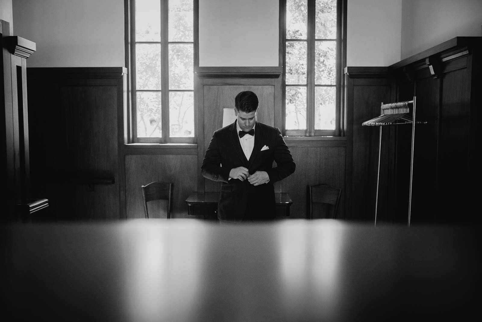 The groom wears his tuxedo as he gets ready perfectly symmetrical photographed at Hotel Emma