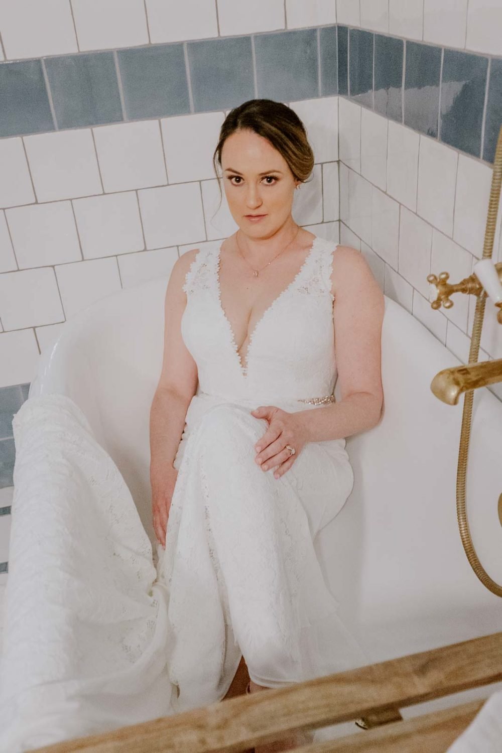 A beautiful bride in her gorgeous gown set an a bath tub posing for a photograph at Hotel Emma in her suite