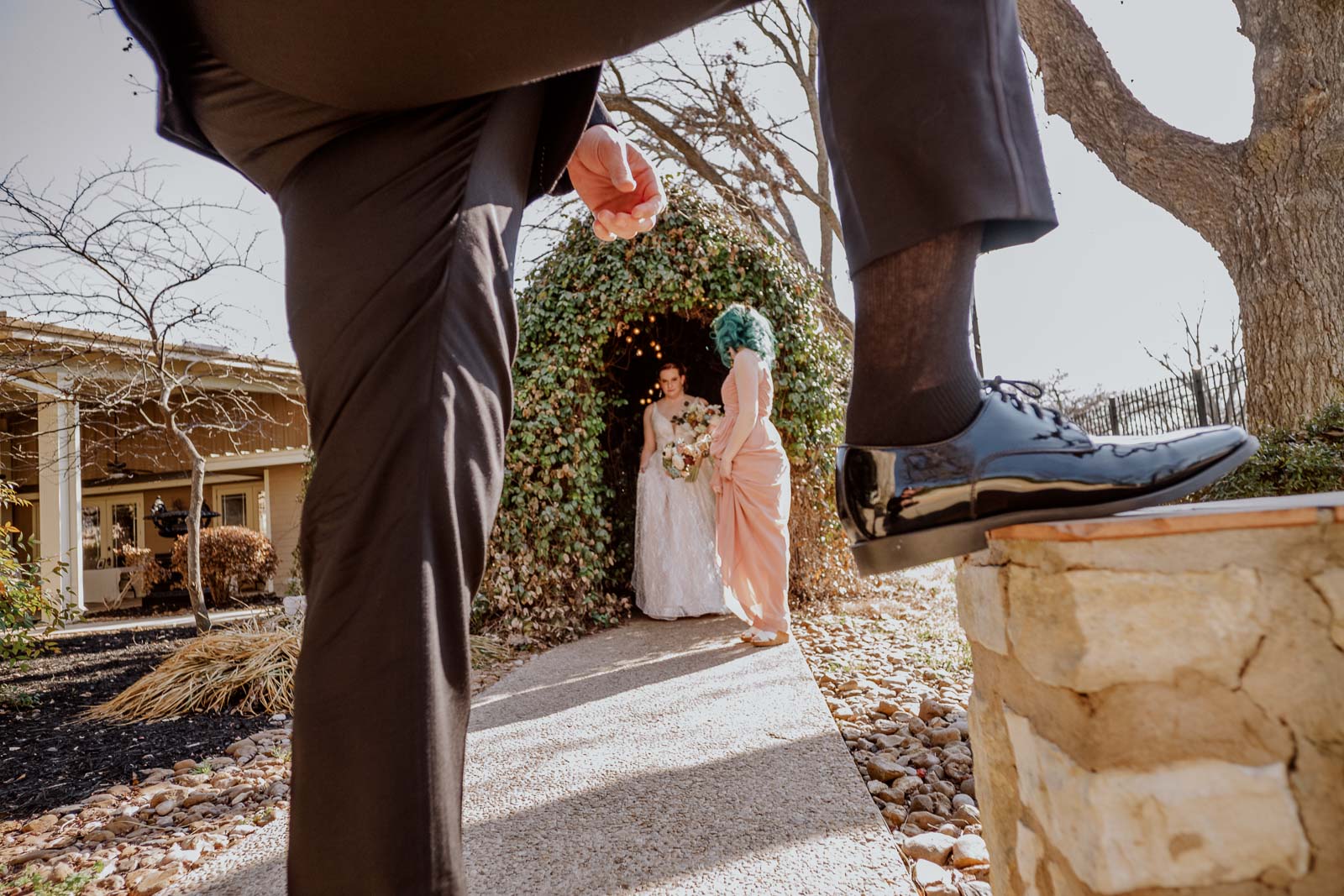 A comical perspective caption for the Bryce brothers legs as she gets ready to enter the wedding ceremony with her sister-in-law background at Spinellis wedding venue