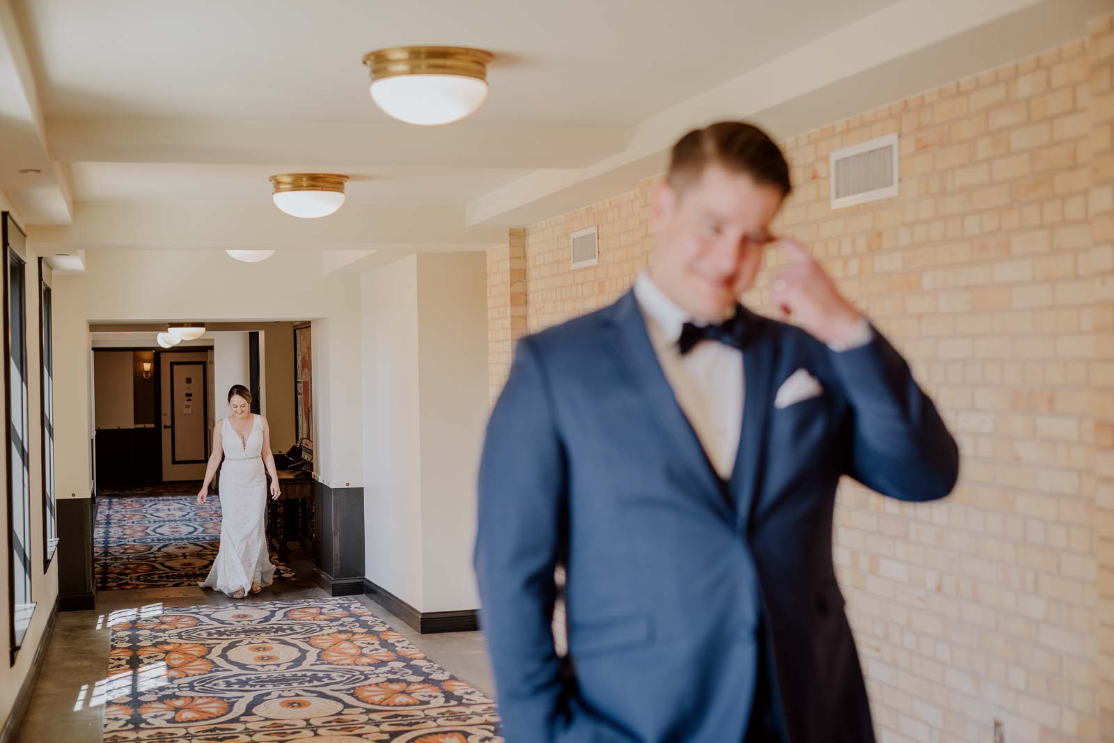 In a quiet moment the bride walks up to her groom for their first look at Hotel Emma