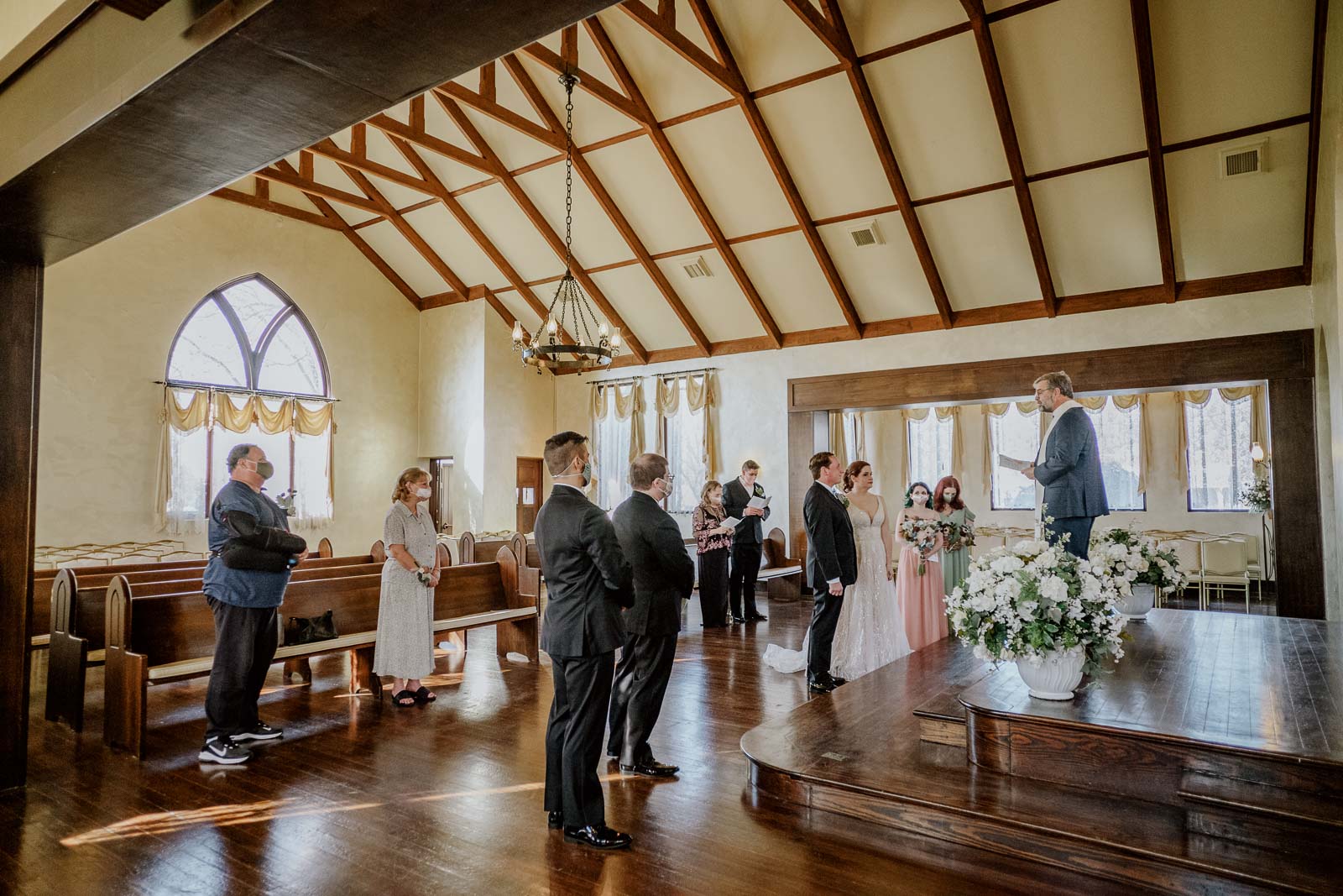  A side view of the wedding ceremony with the couple and the preacher and a meal for the family to the Covid pandemic at Spinellis wedding venue in comfort Texas