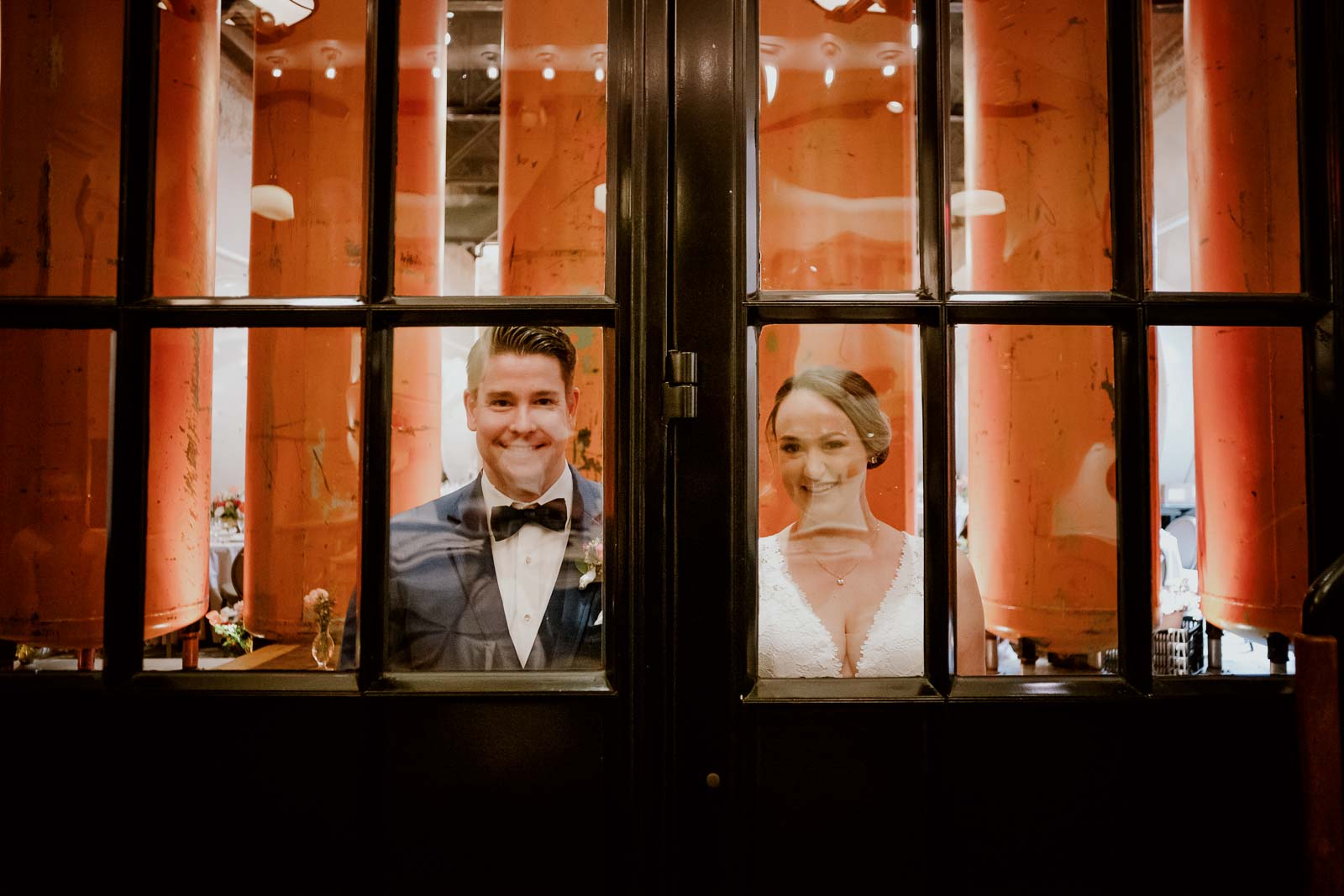 The couple pose against a window frame perfectly framed by the photographer in a awesome image