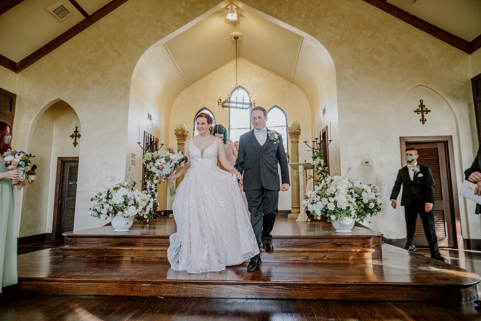 Just married couple walking down the steps at Spinellis wedding venue income taxes she is holding her bouquet