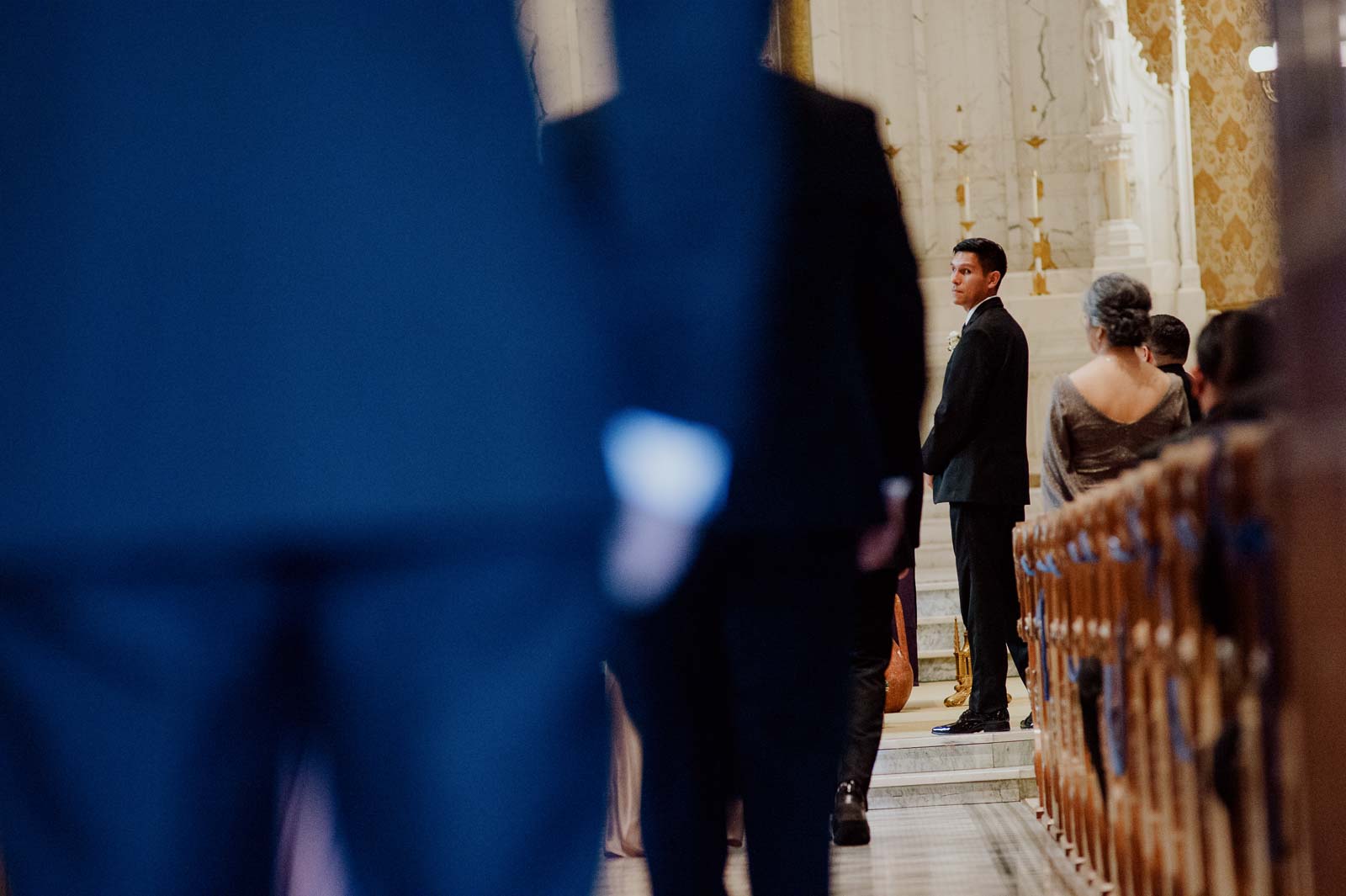 As the ceremony commences the groom looks over his shoulder toward his bride