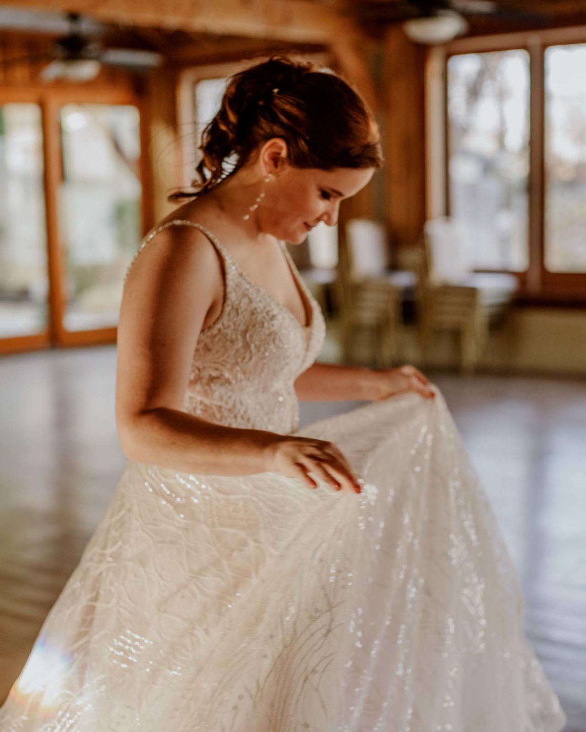 The bride looks down at her dress and a vertical shot at Spinellis wedding venue