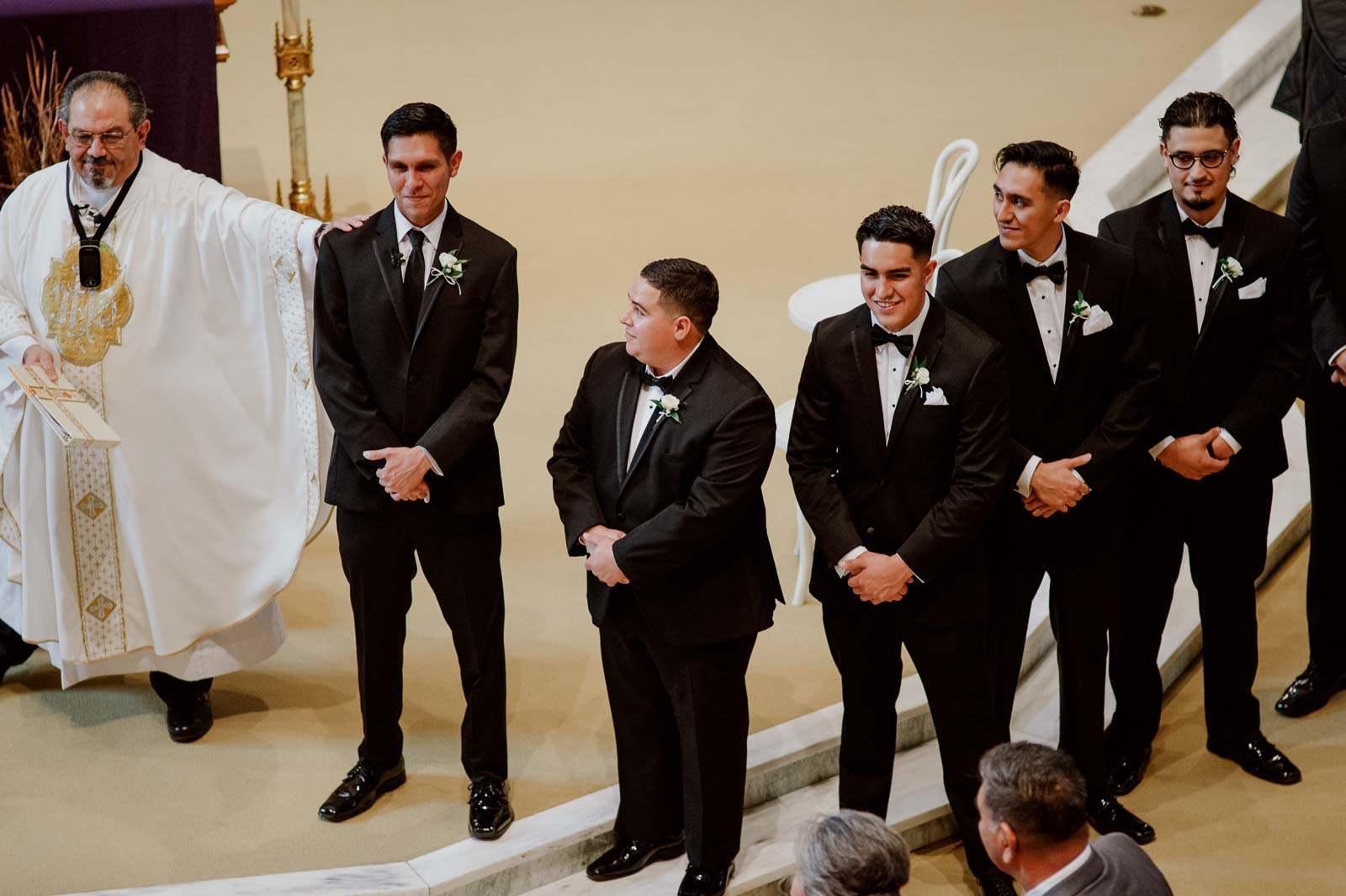 In a cheerful moment the groom is his pride for the first time and the priest rest his hands on his shoulder reassuring him that all is well and a moment of camaraderie