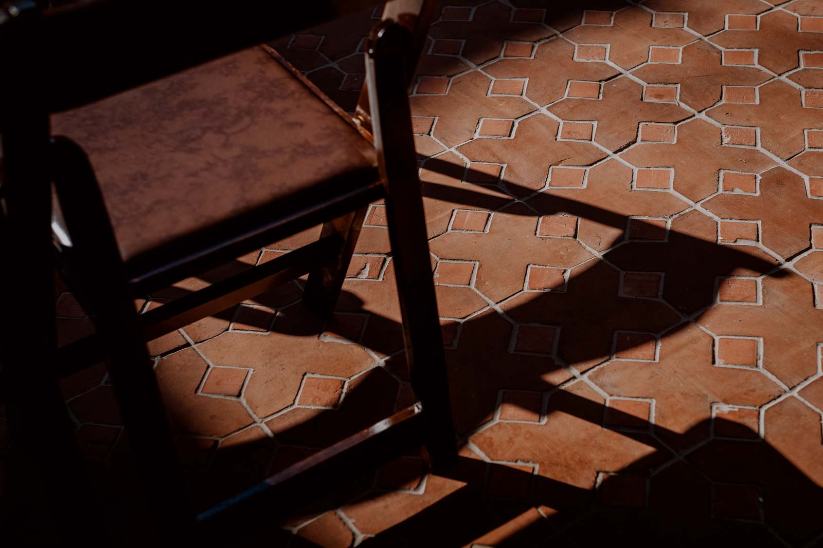 Chair casting shadows in the courtyard at Hotel Emma