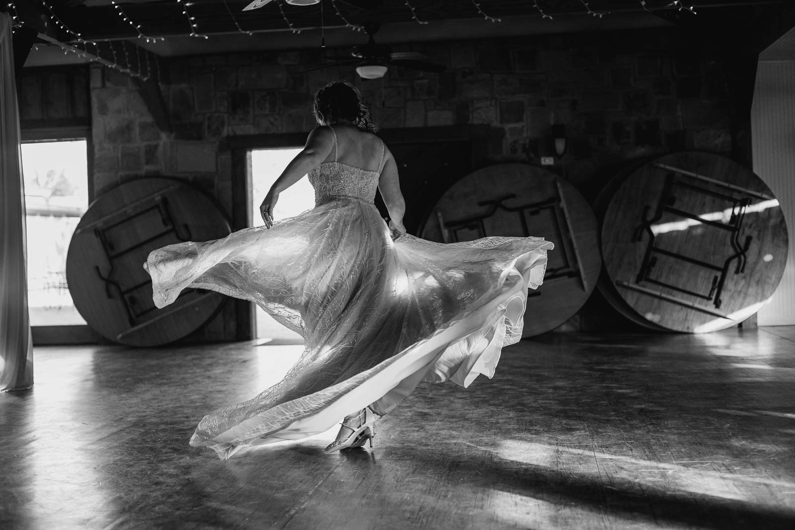 A monochrome image of the bride twirling capturing the dress beautifully on a Leica MP rangefinder