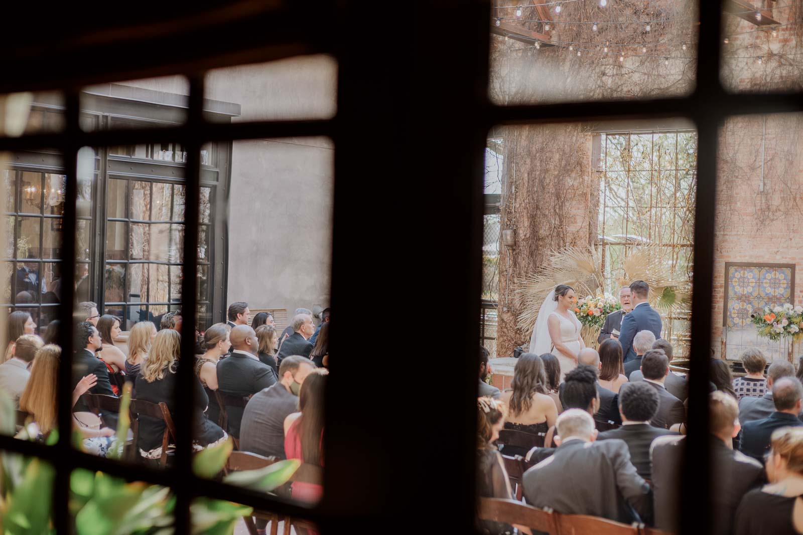 The wedding ceremony for a craft through a window at the courtyards at Emma