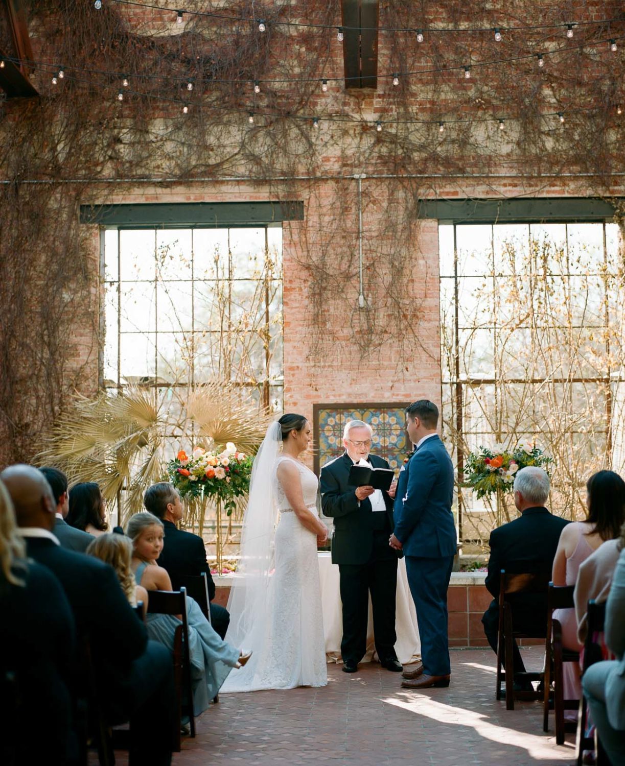 Photograph from the back of the ceremony during a wedding ceremony in the courtyard at Hotel Emma