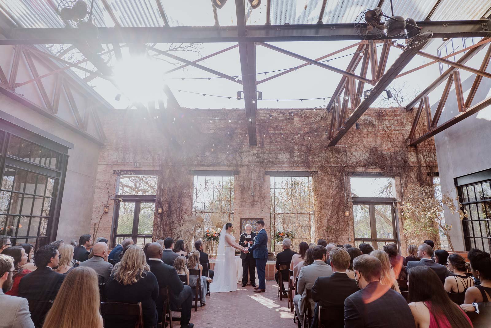 Photograph from the back of the ceremony during a wedding ceremony in the courtyard at Hotel Emma