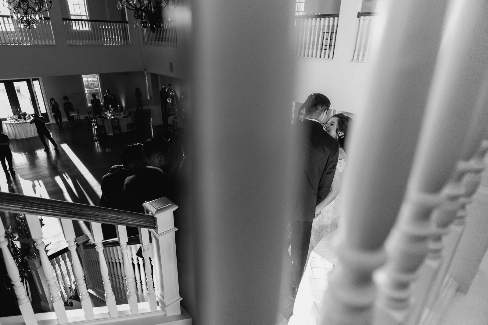 the bride and groom look at each other as they do send they descend down grand staircase  A winter wedding at Kendall Point, Boerne, Hill Country Texas-Leica photographer-Philip Thomas Photography