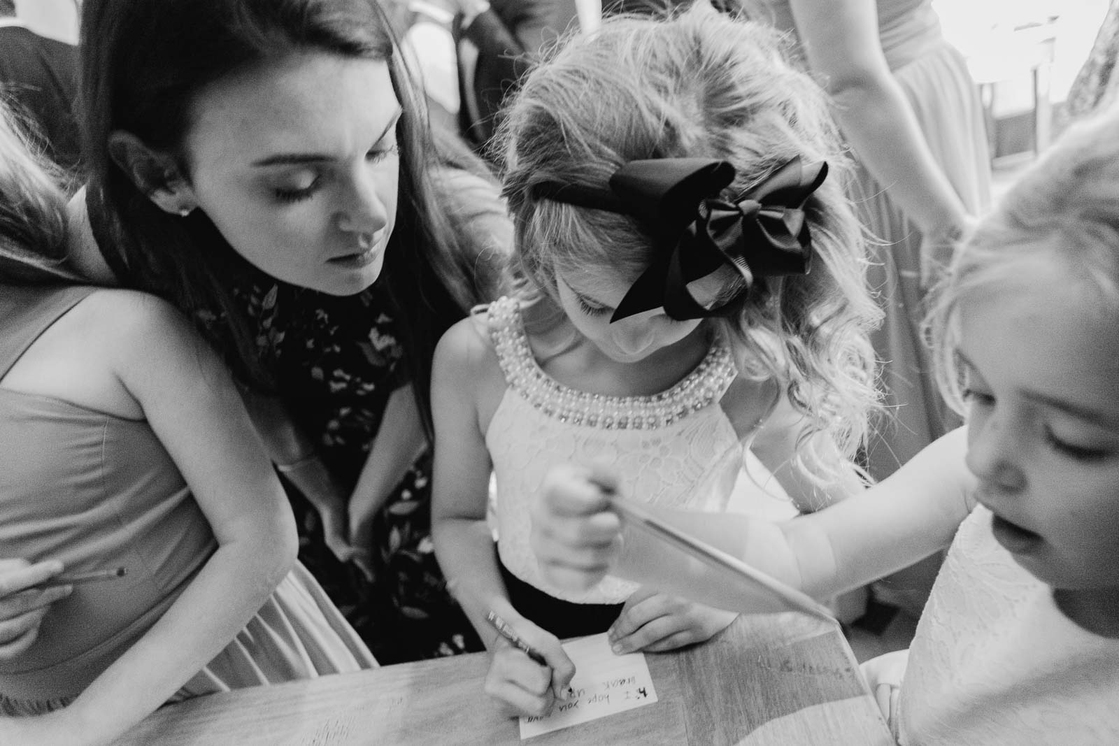 Philip Thomas captures a beautiful little girl signing a thank you note reportage wedding photography