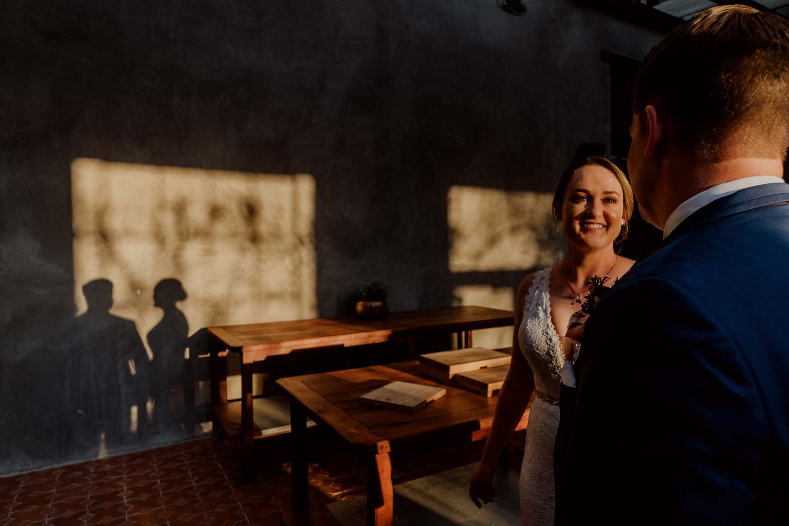 A couple share a light hearted moment as the shadows a cast against the wall at Sunset Hotel Emma