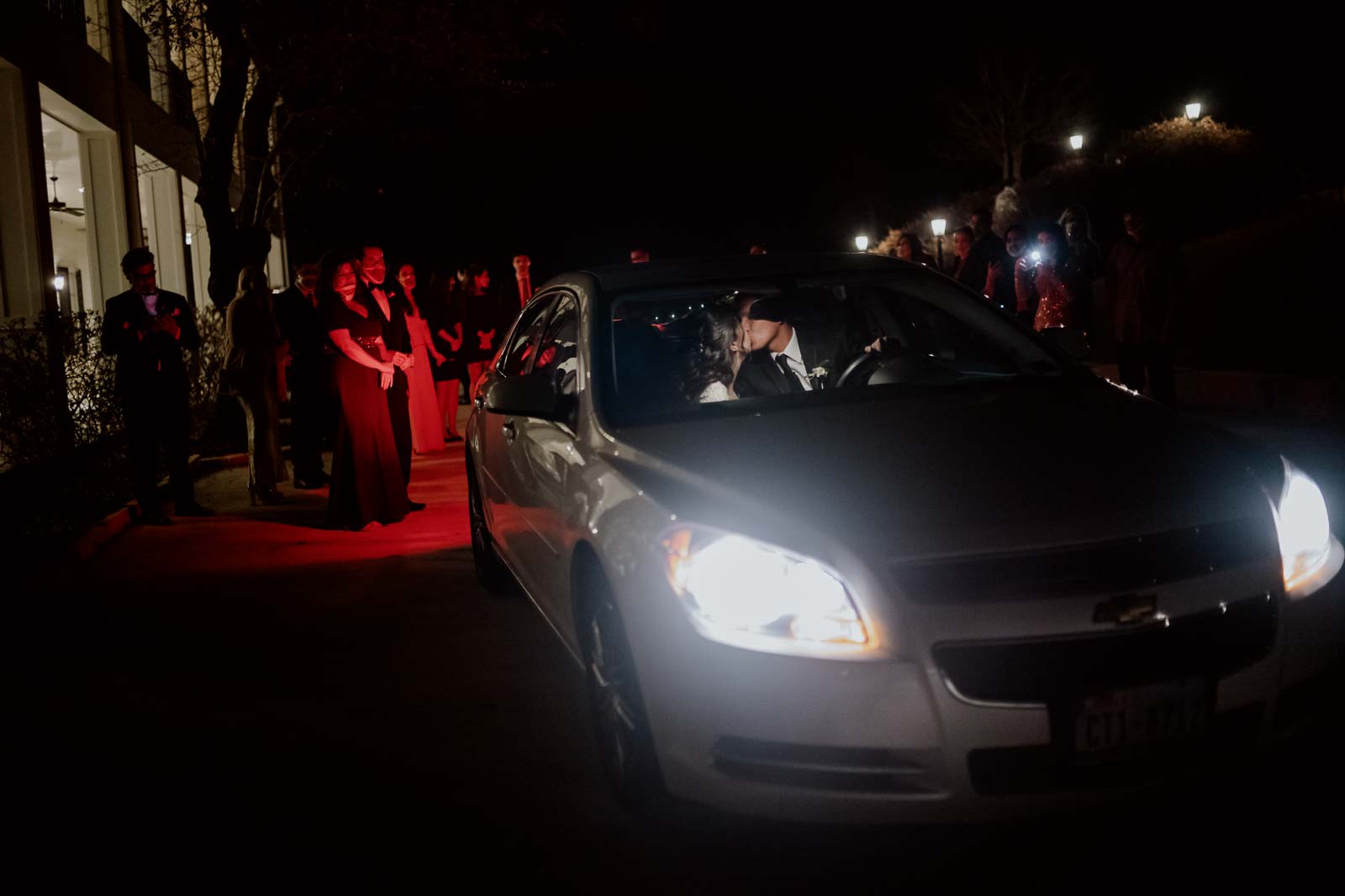 What is the couple in the car a couple kiss as family and friends gather around the park at Kendall point wedding venue