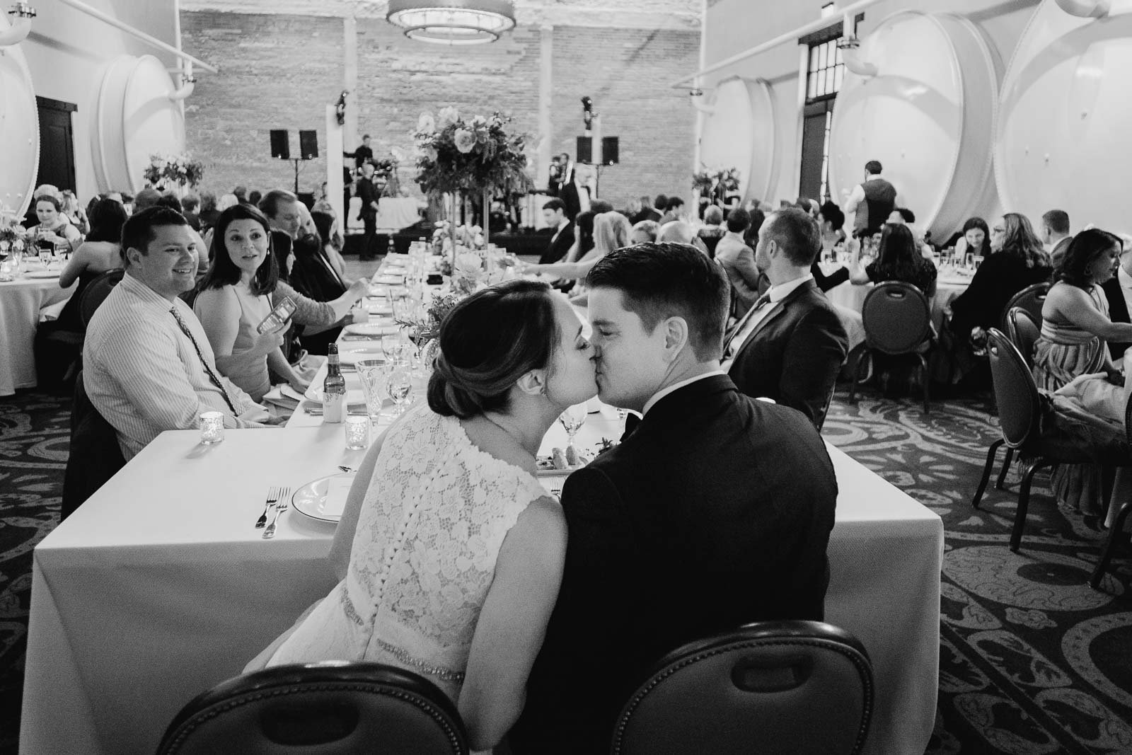 Couple kiss at their table Hotel Emma Wedding and reception modern documentary weddings-Leica photographer-Philip Thomas Photography