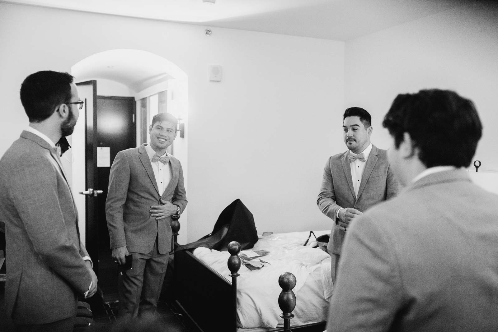 The groomsmen share a joke in the bedroom at Hotel Valencia