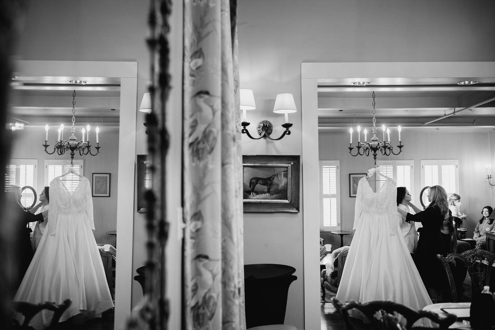 In a mirror reflection the bride stress hangs wildly wildly mother of the bride talks to her daughter
