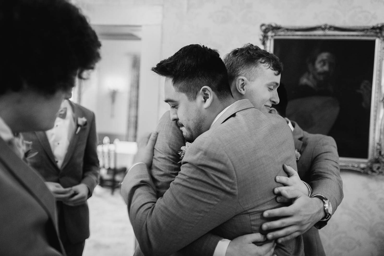 Hugs all around as a groom hugs one of the groomsmen