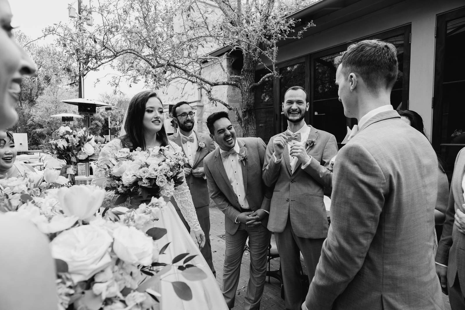 The bridal parties around the bar and groom as laughs abound in the groomsmen
