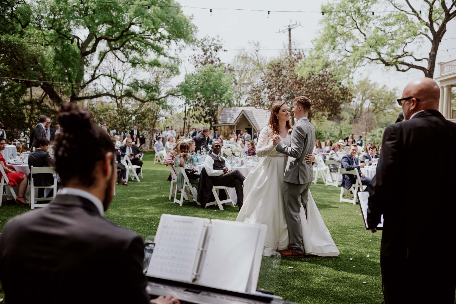 The bride and groom enjoy their first dance as the band accompanies them