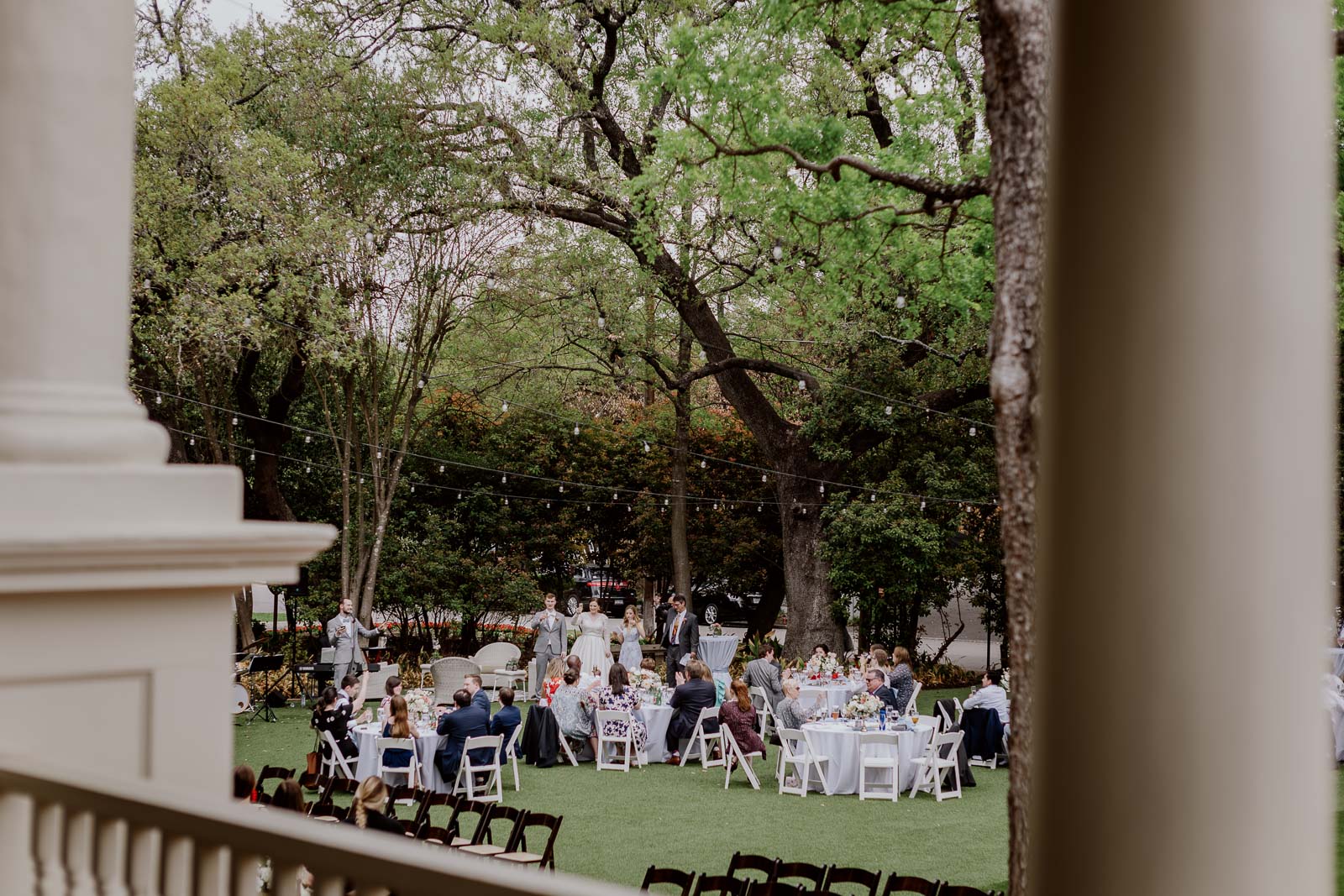 A lovely wide-angle photograph and a balcony out towards the lawn shows couple being toasted