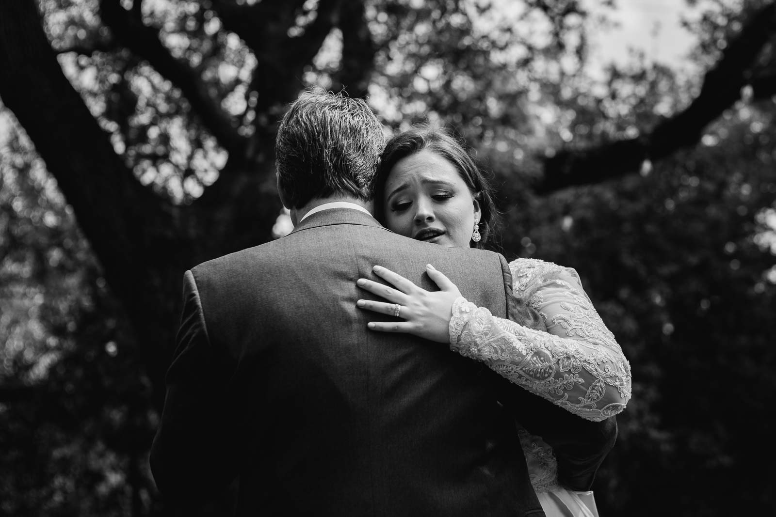 An emotional bride hugs her father with tears streaming down her face close-up paragraph on a Leica M rangefinder in black-and-white