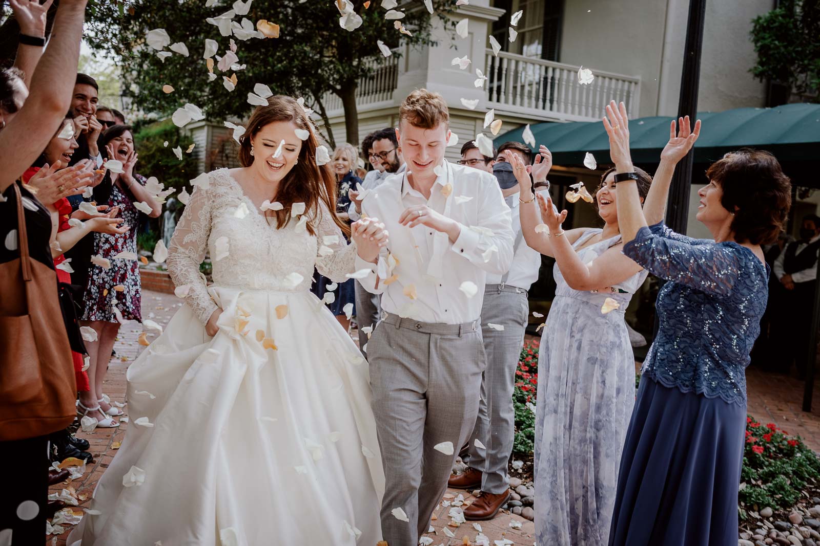 During the spring wedding the bride and groom run through the crowd on the exit as petals are for an up in the air in celebration