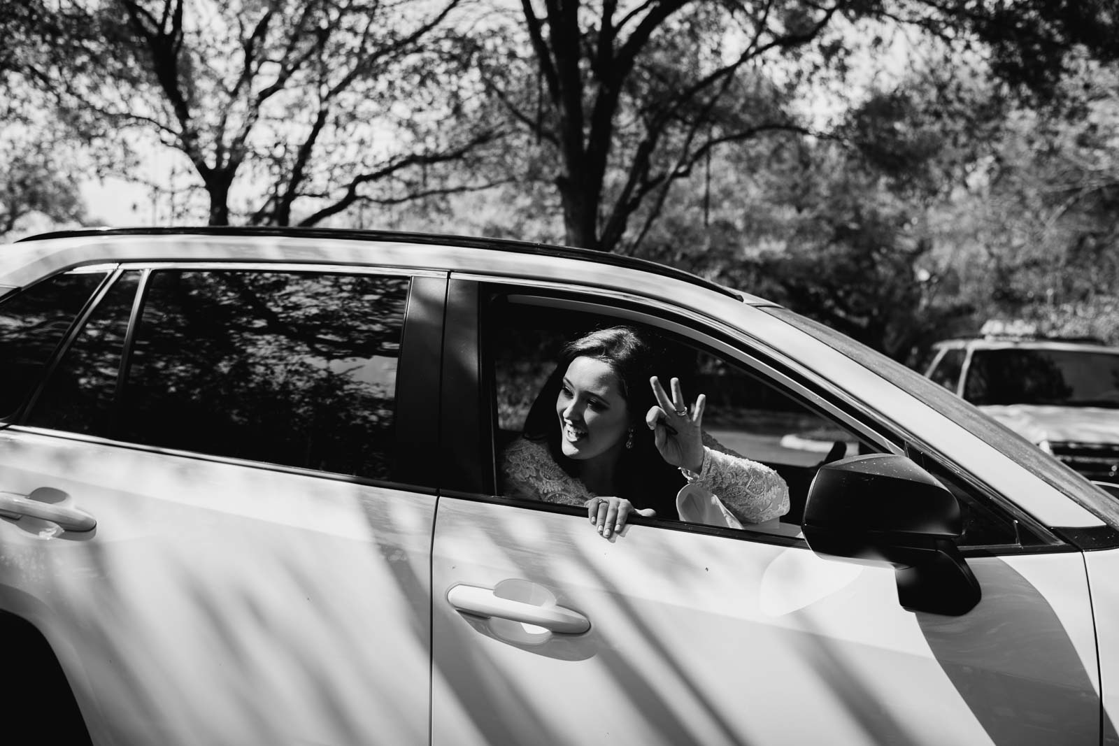 The bride and groom drive away on an exit the bride pokes her head through the window and waved back at the parents