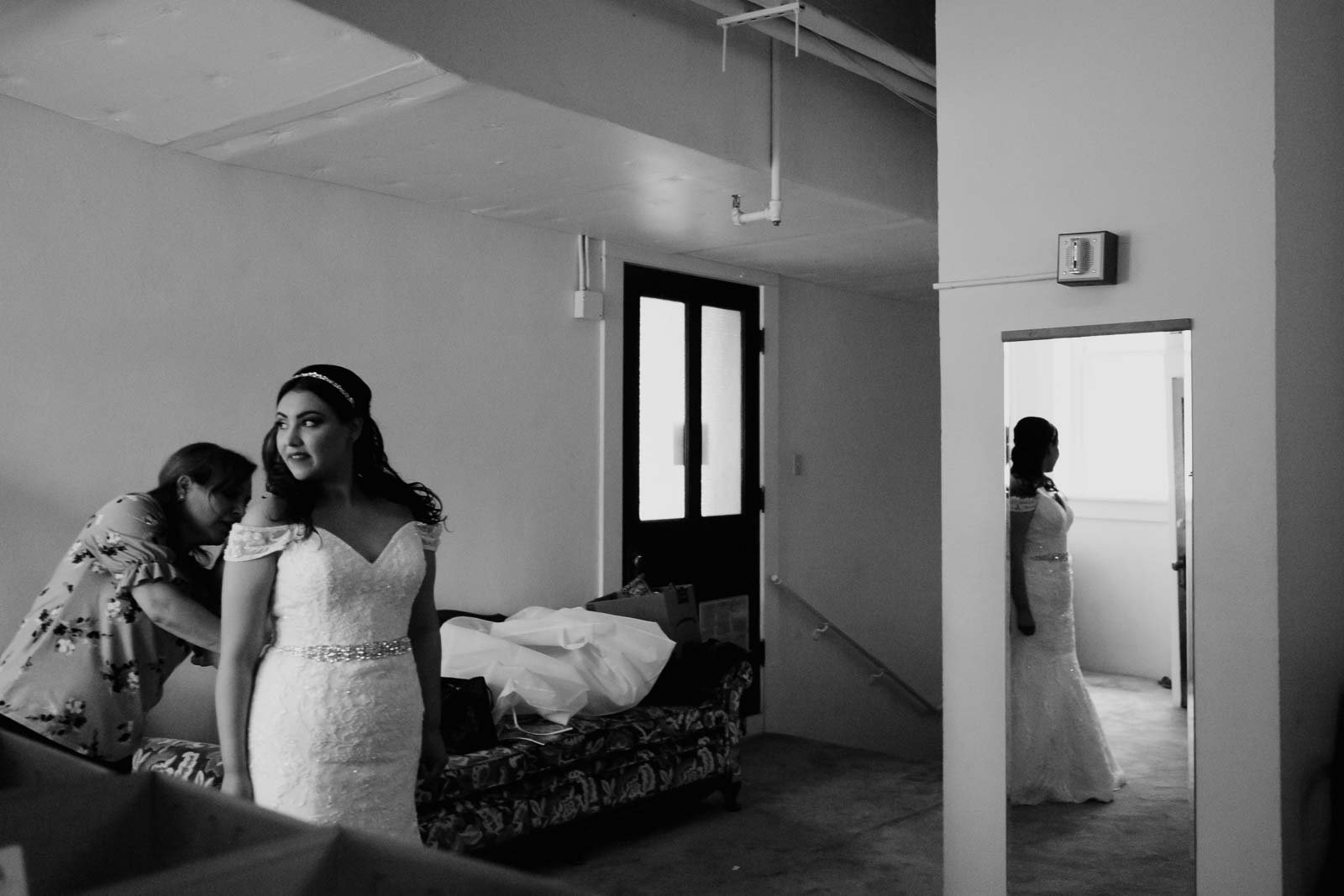 With a helping hand from her mother the bride gazes out of window Sacred Heart Chapel-Leica photographer-Philip Thomas Photography