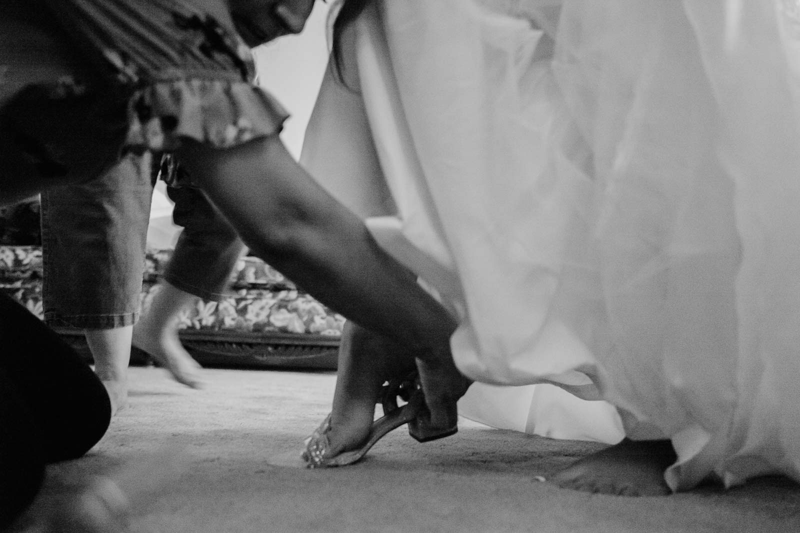 The bride slips on her wedding shoes at With a helping hand from her mother the bride gazes out of window Sacred Heart Chapel-Leica photographer-Philip Thomas Photography