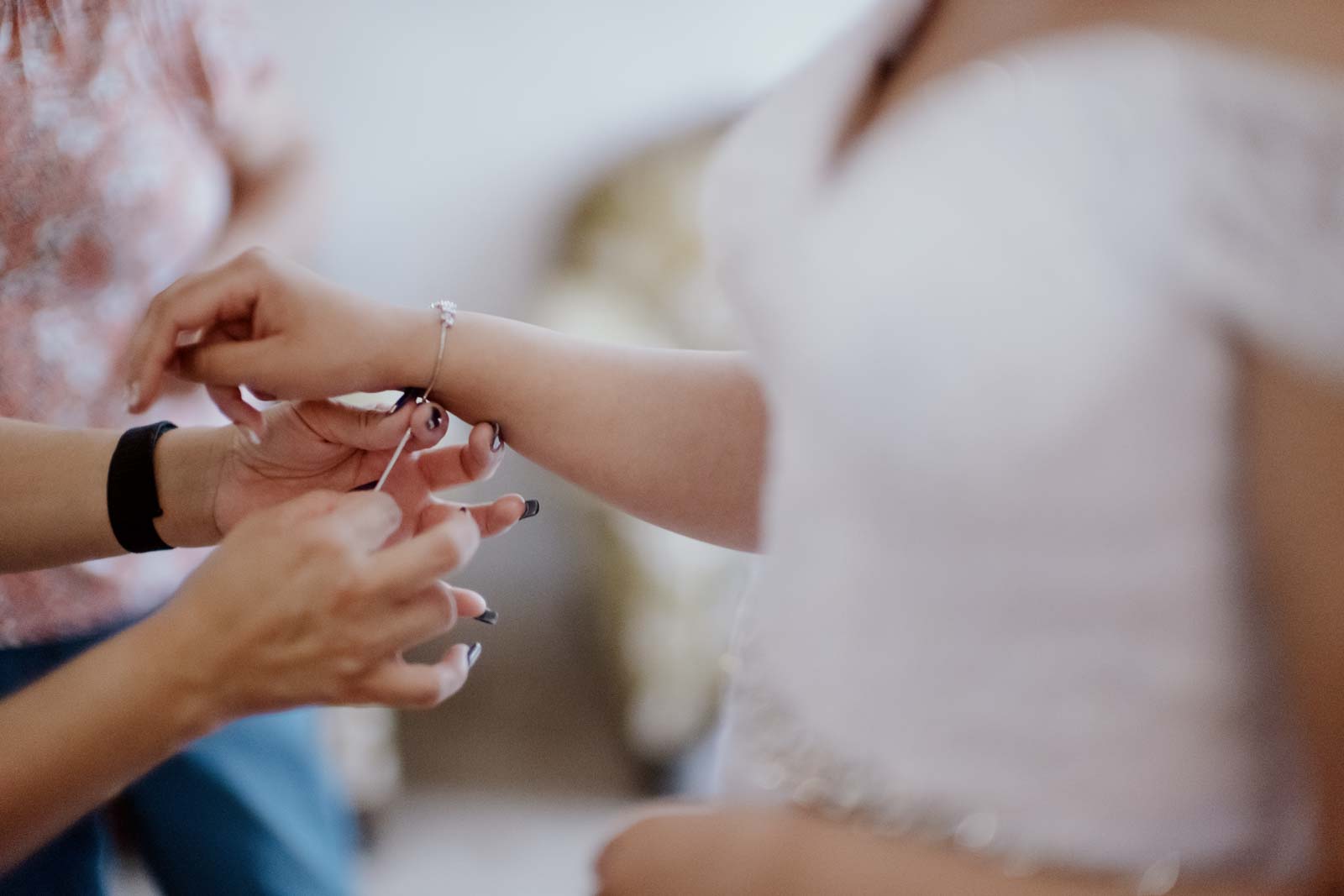 Jewellery is added to brides wrist by her mother Sacred Heart Chapel-Leica photographer-Philip Thomas Photography