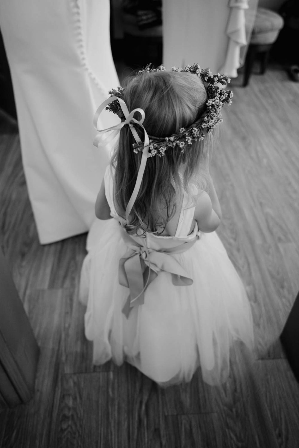 The back of a beautiful flower girl showing her flowers in her hair Close up Decor of flowers on her wedding day at the veranda