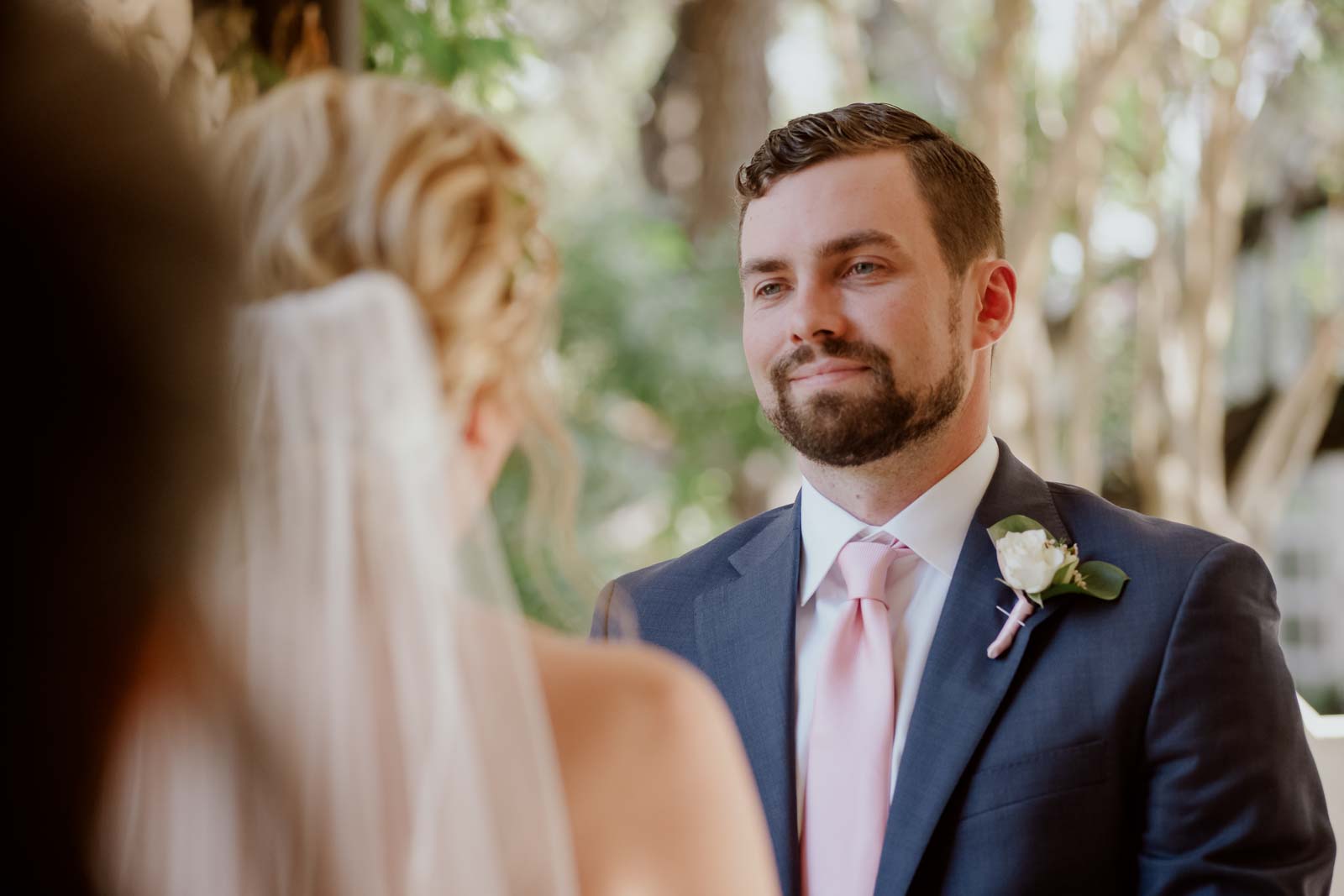 A close-up of the groom looking adoringly on his wife during the ceremony
