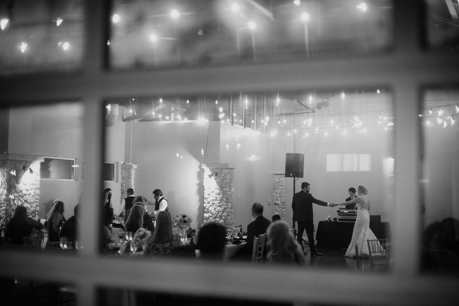 The couples first dance at a wedding reception why don’t go shot with lights in the ceiling
