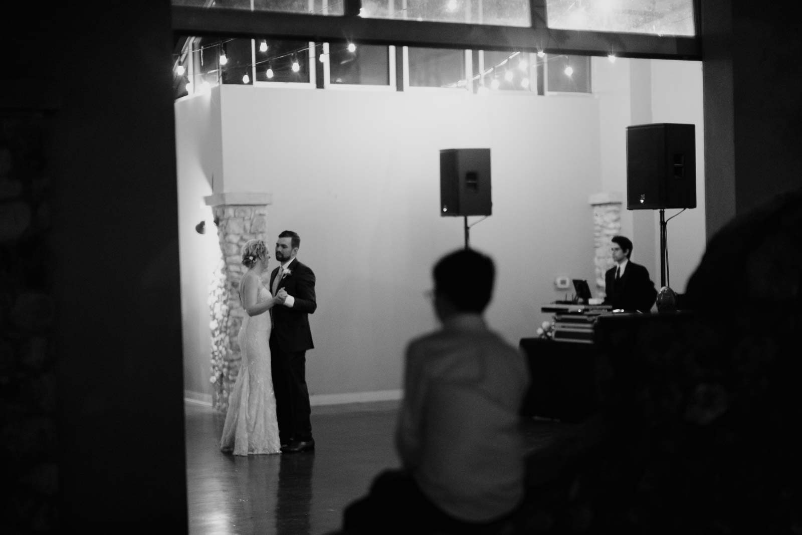 Couples first dance as the grooms san sits on a wall looking on and the DJ on the right side