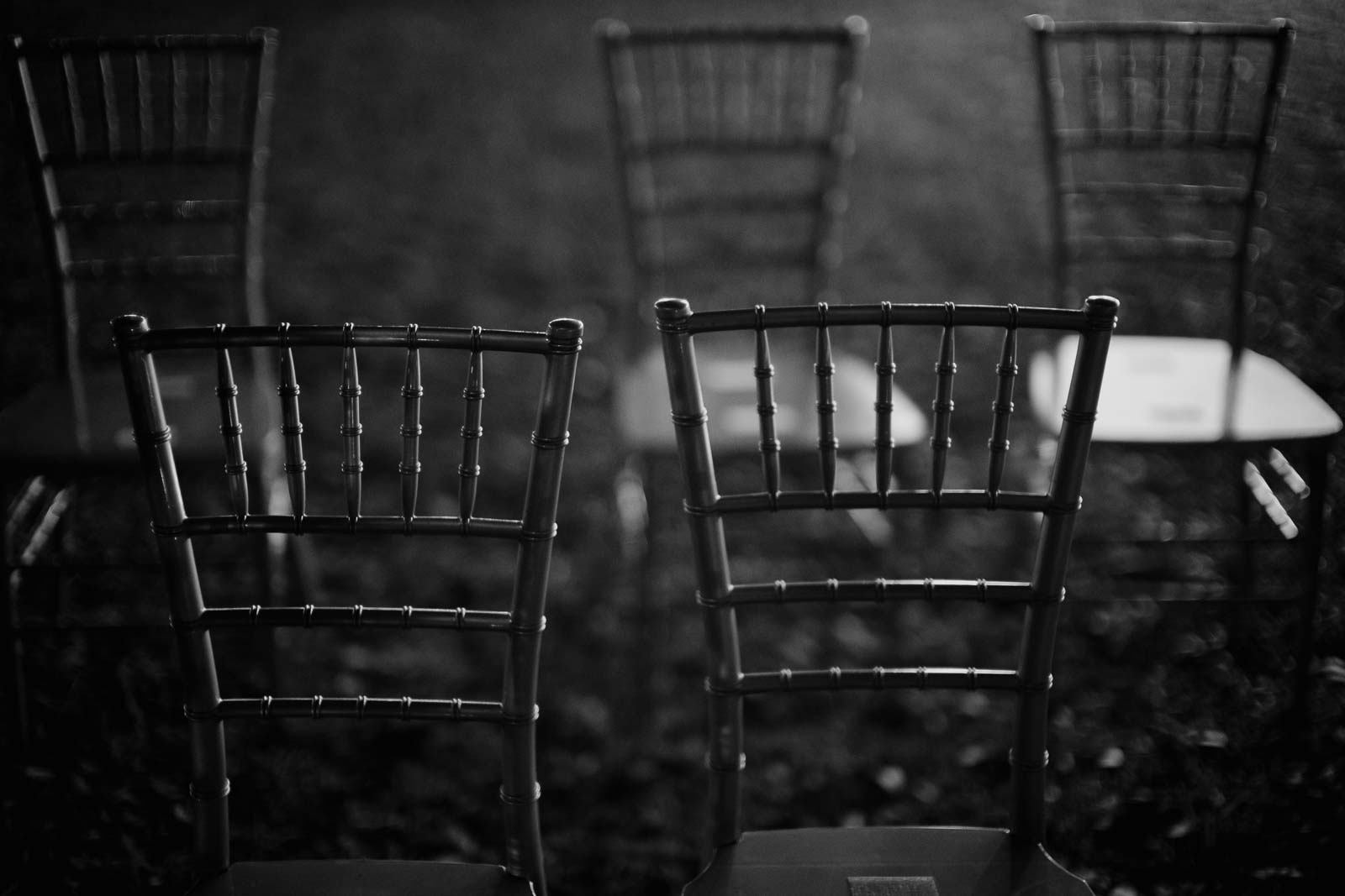 Gorgeous monochrome photograph of the wedding chairs used to turn the ceremony backlit