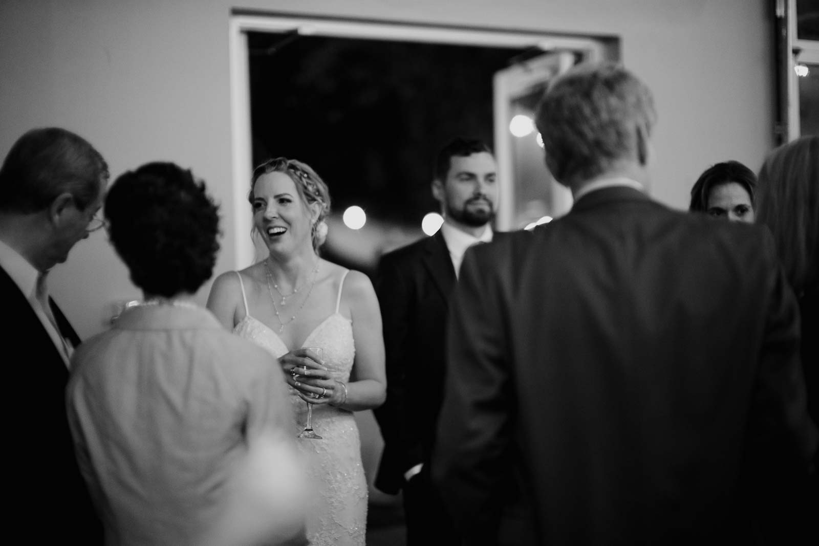 During the wedding reception a couple mingle with guests monochrome Leica photographer