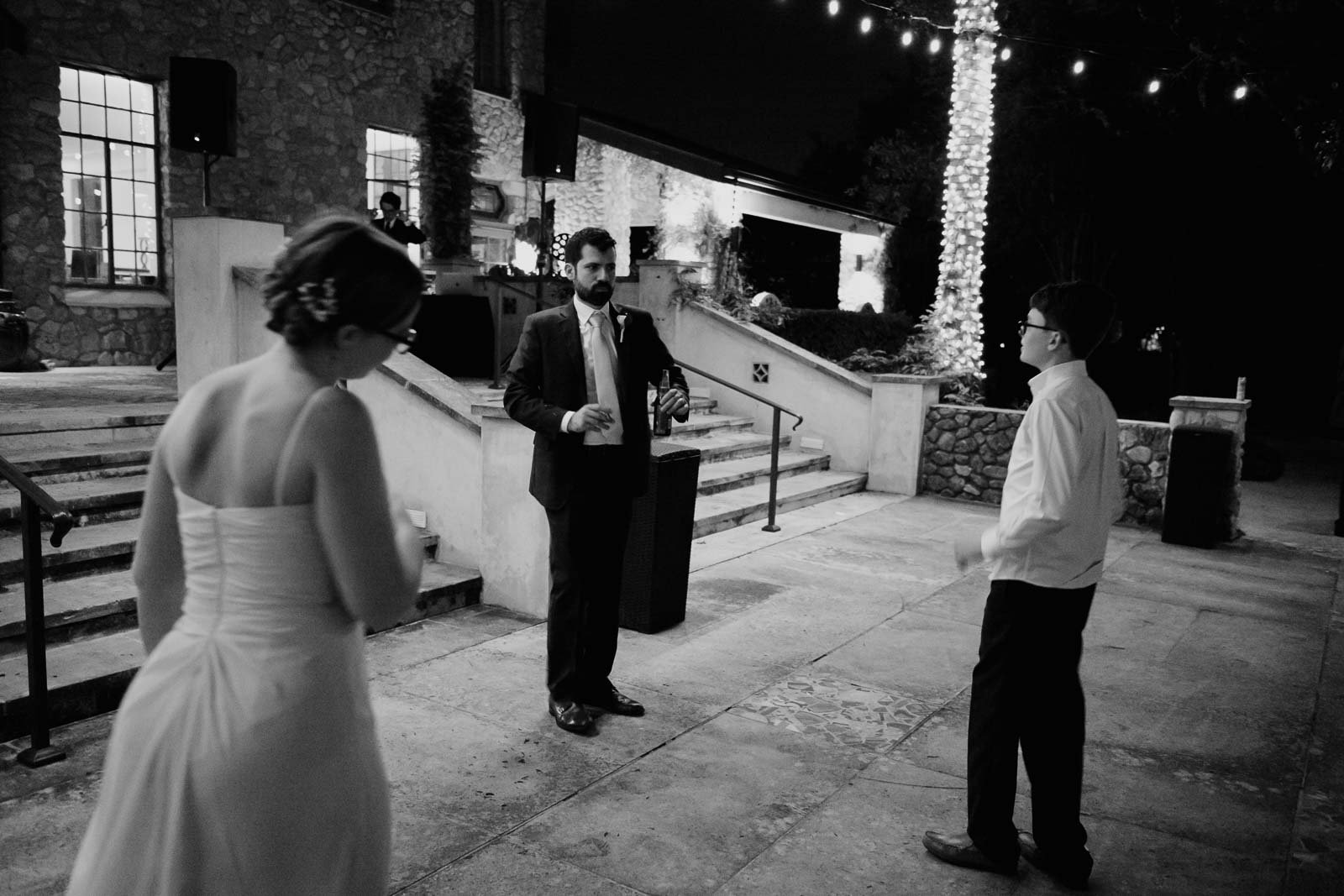 At this small wedding a few guests start to dance on the patio at the veranda under available light