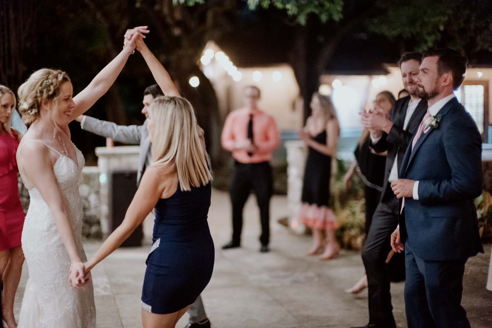 Groom looks on his bride as she dances with a guest