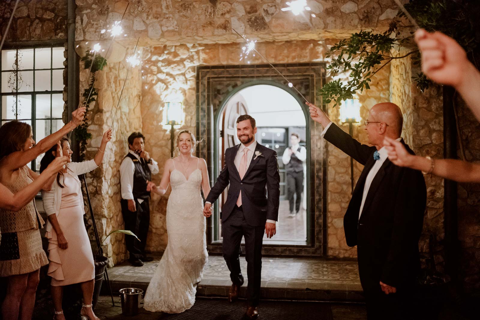 The couple depart the veranda as guests light up sparklers